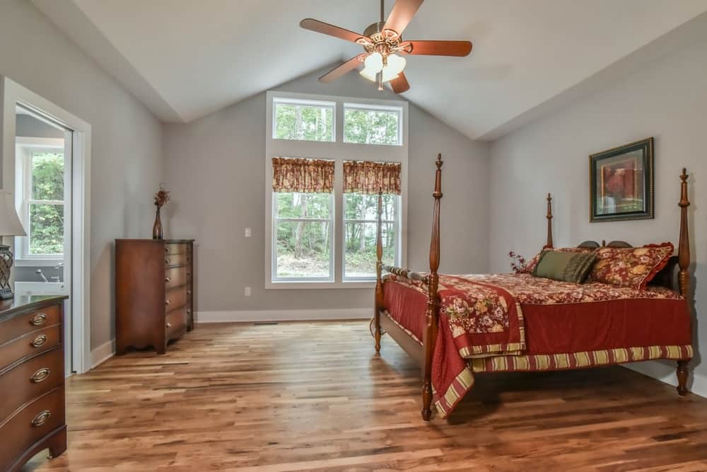 Bedroom with a vaulted ceiling, ceiling fan and hardwood floors