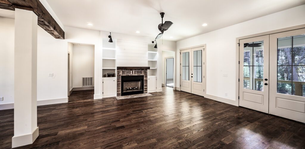 Open living area with dark hardwood floors, built-in shelving and french doors