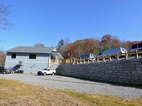 Stone retaining wall and gravel drive completed by Cool Mountain Construction