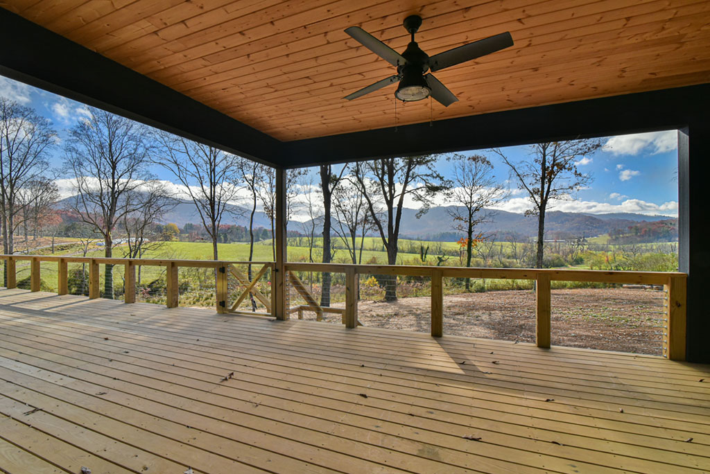 Covered back deck with a stained wood ceiling, ceiling fan and open mountain views