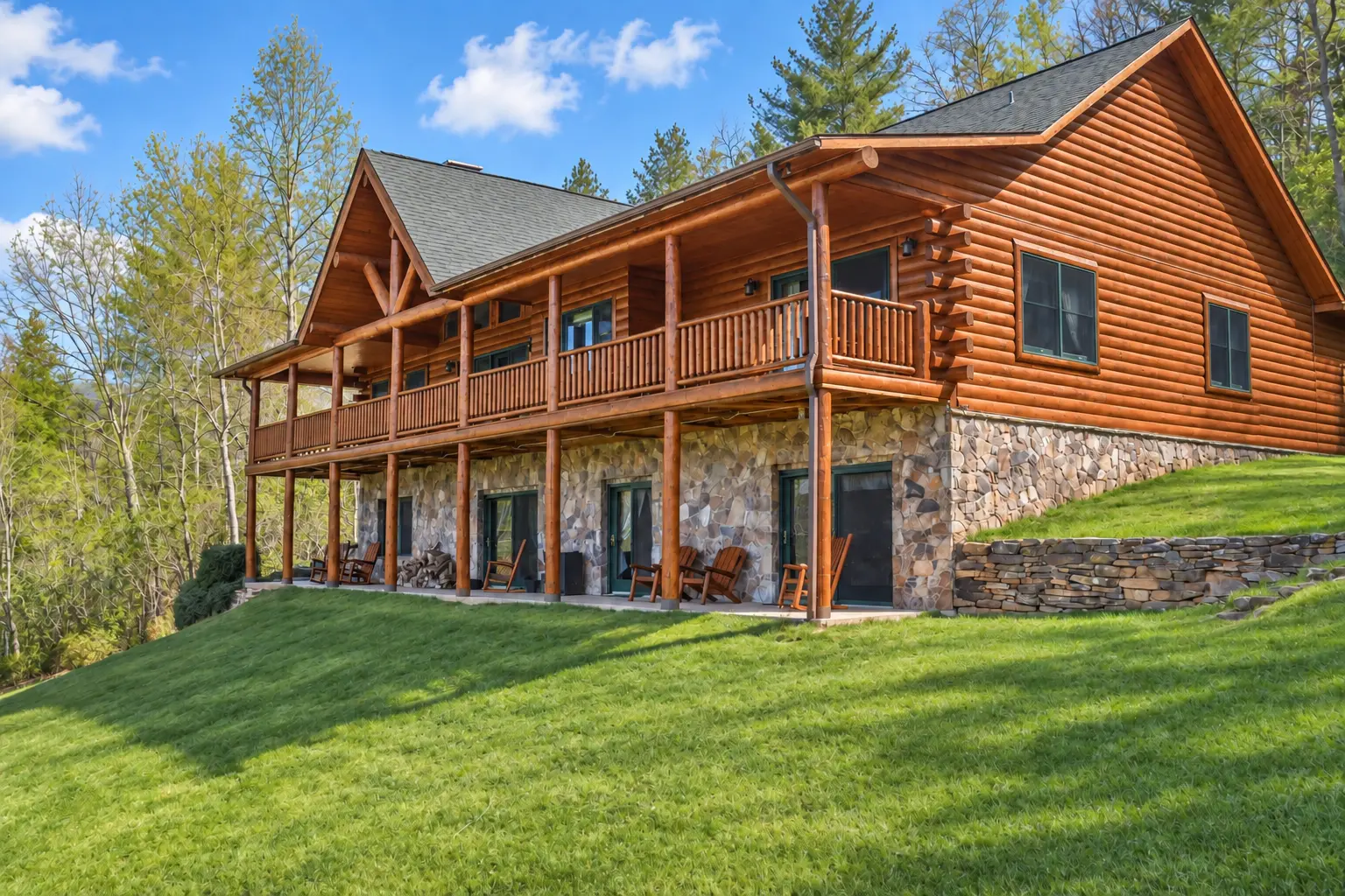 Log-sided mountain home with wraparound porch above a stone lower level