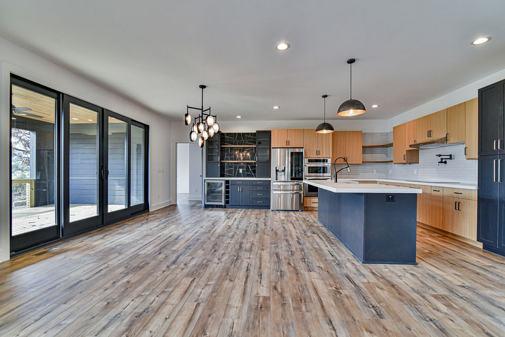 Open living, dining and kitchen area with a large island and sliding glass doors