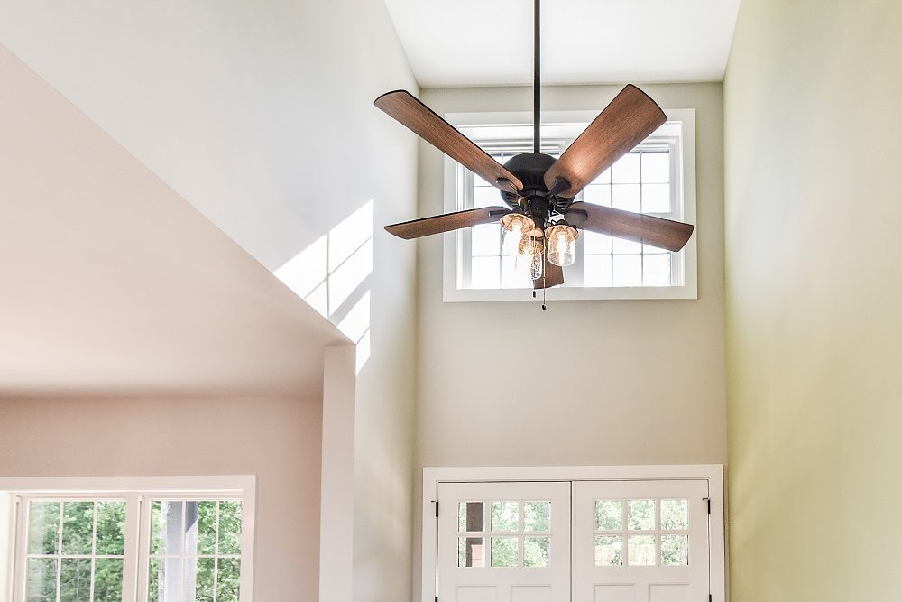 Two-story entry with a vaulted ceiling, ceiling fan and glass front doors