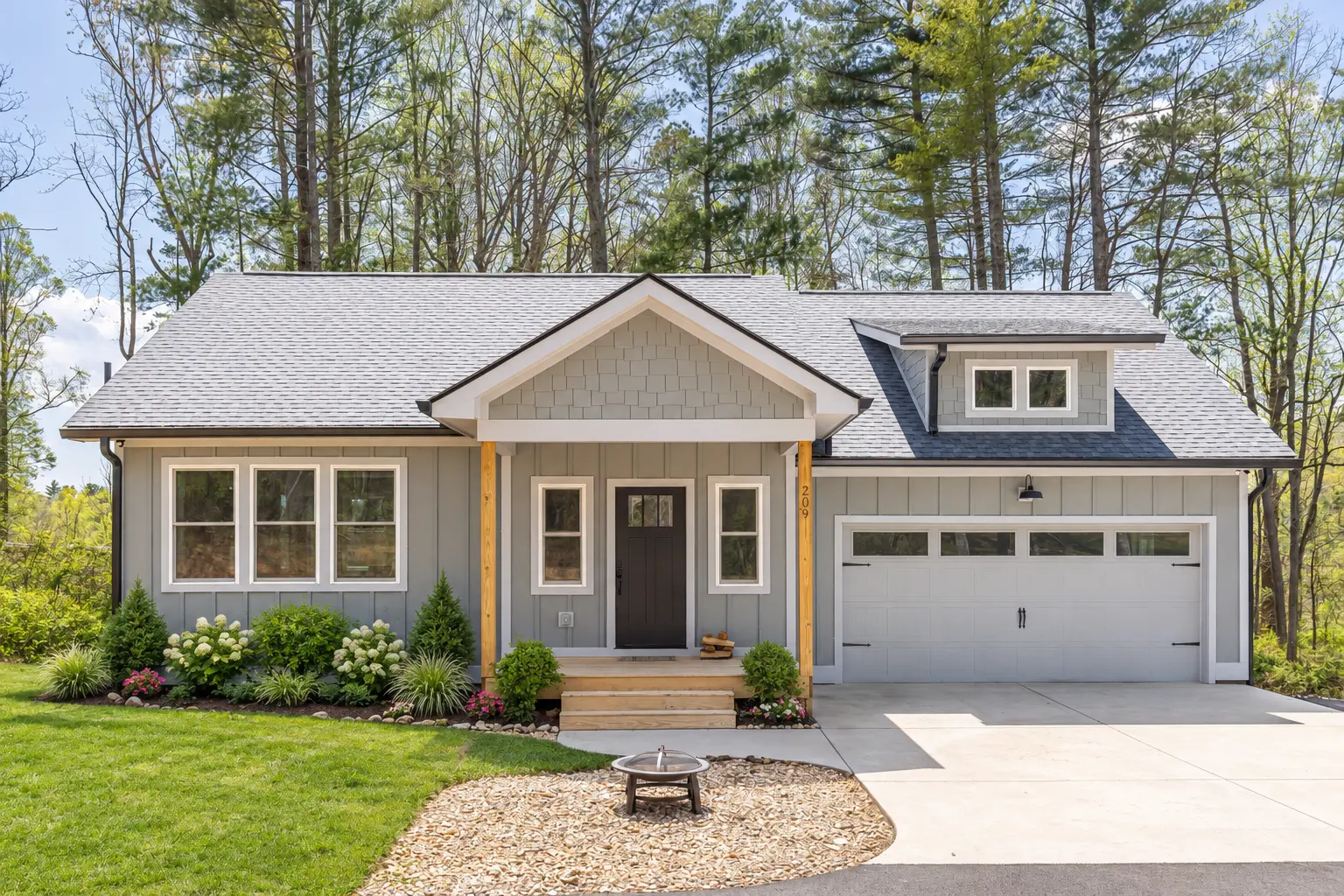 Gray craftsman ranch home with covered entry and attached garage