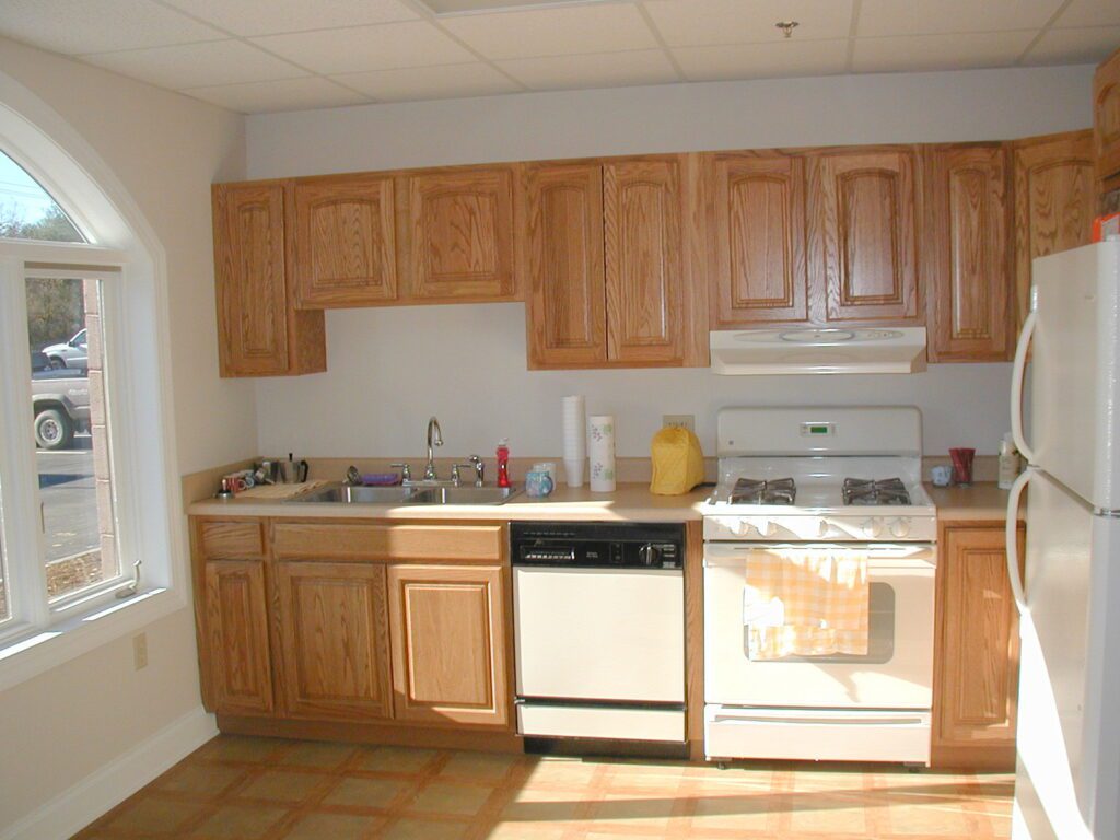Kitchen with oak cabinets and an arched window at Resinart in Fletcher, NC