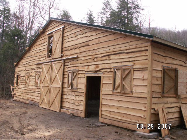 Rough-cut lumber exterior and sliding barn doors on the finished riding arena
