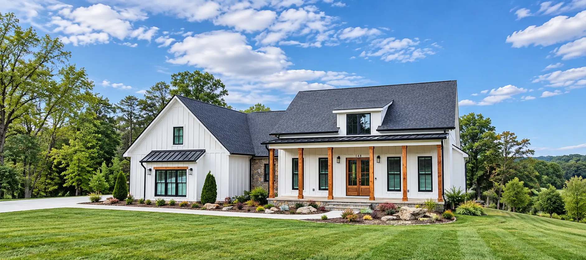 White board-and-batten farmhouse with cedar porch posts and a wide green lawn