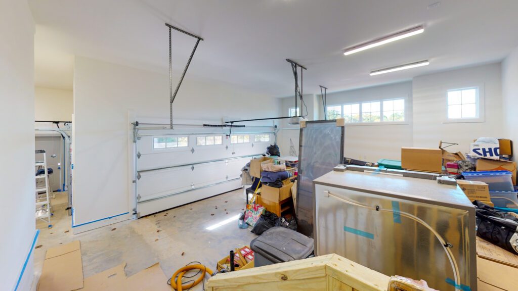 Garage interior during construction with an insulated overhead door and finished walls