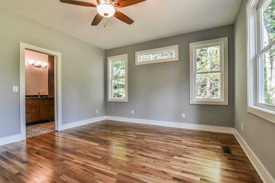 Bedroom with a vaulted ceiling, ceiling fan and a doorway to the bathroom