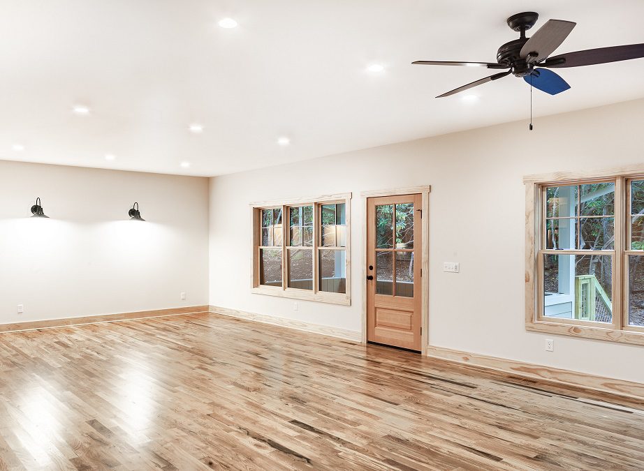 Living room with hickory floors, barn-style wall sconces and windows to the porch