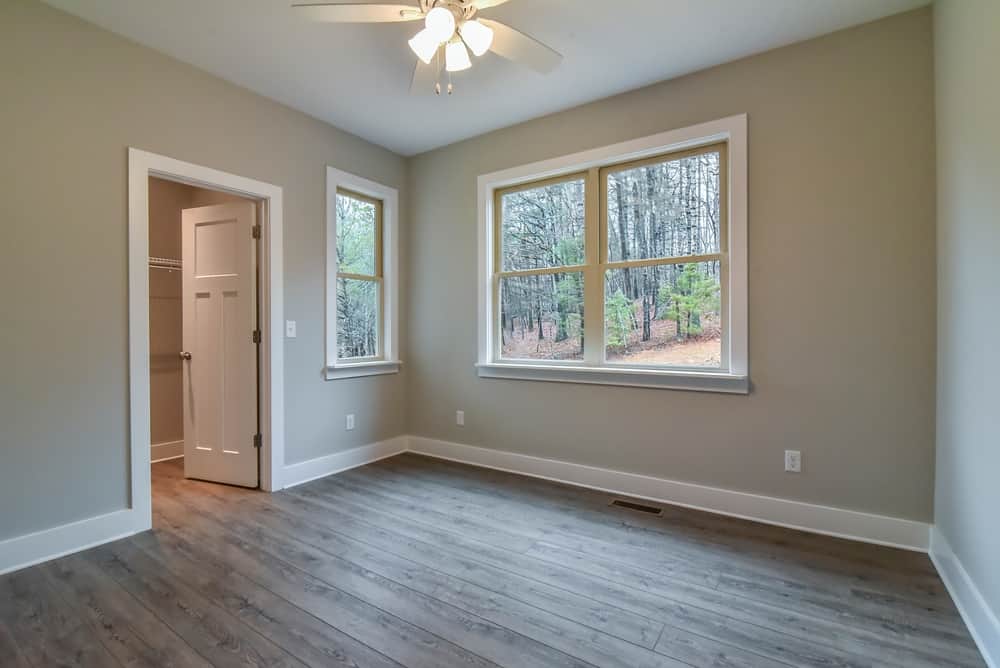 Bedroom with a closet, windows to the trees and wood-look flooring