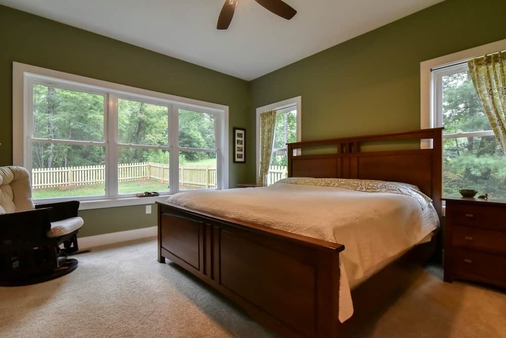 Primary bedroom with a wall of windows overlooking the backyard