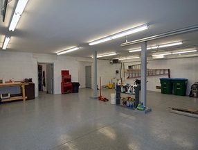 Service garage with a sealed floor, steel column and overhead lighting