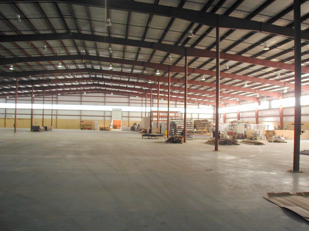 Wide view of the high steel trusses inside the Resinart industrial space