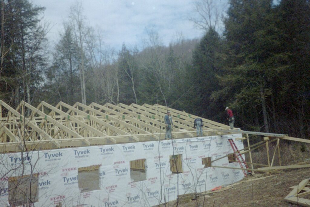 Riding arena in Fairview, NC under construction with trusses being set along the wall