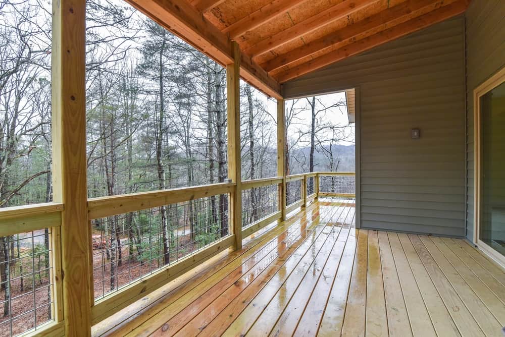 Screened porch with timber posts, a stained wood ceiling and mountain views