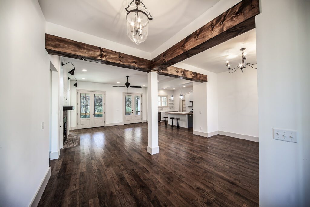 Great room with reclaimed wood beams, a chandelier and a view into the kitchen