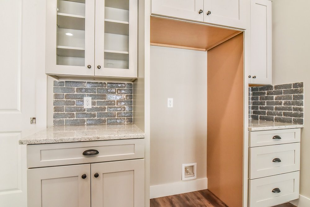 Butler's pantry area with glass-front cabinets, granite counters and a pass-through