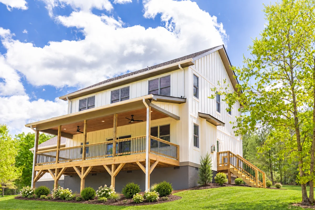Cream two-story home with covered timber porch and deck